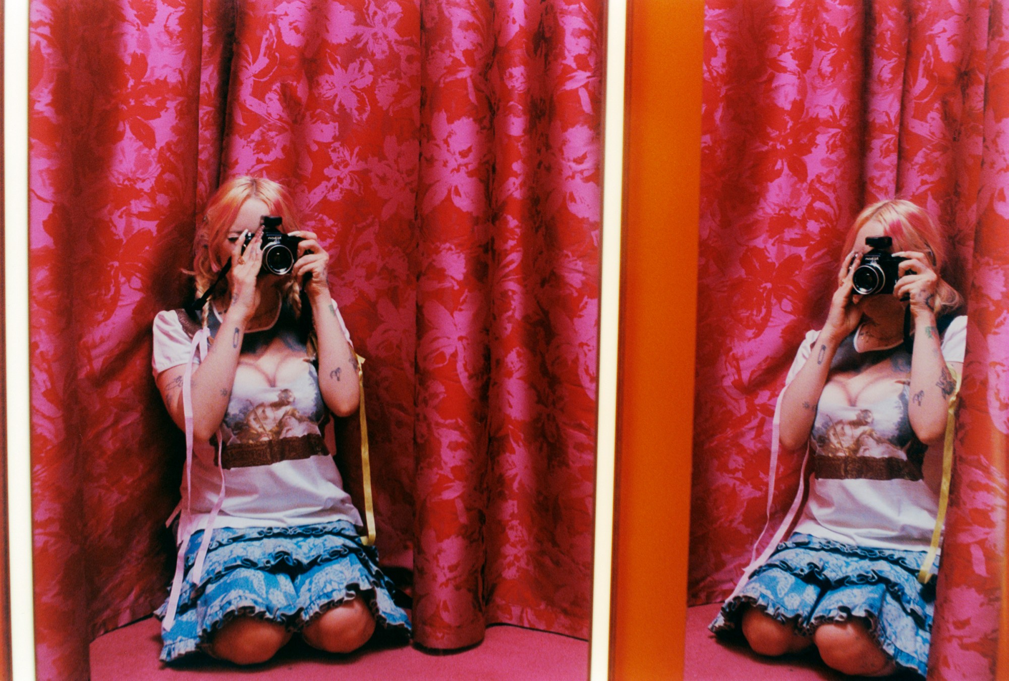 harmony tividad taking a self portrait in a dressing room with pink curtains. Photography Ashley Markle