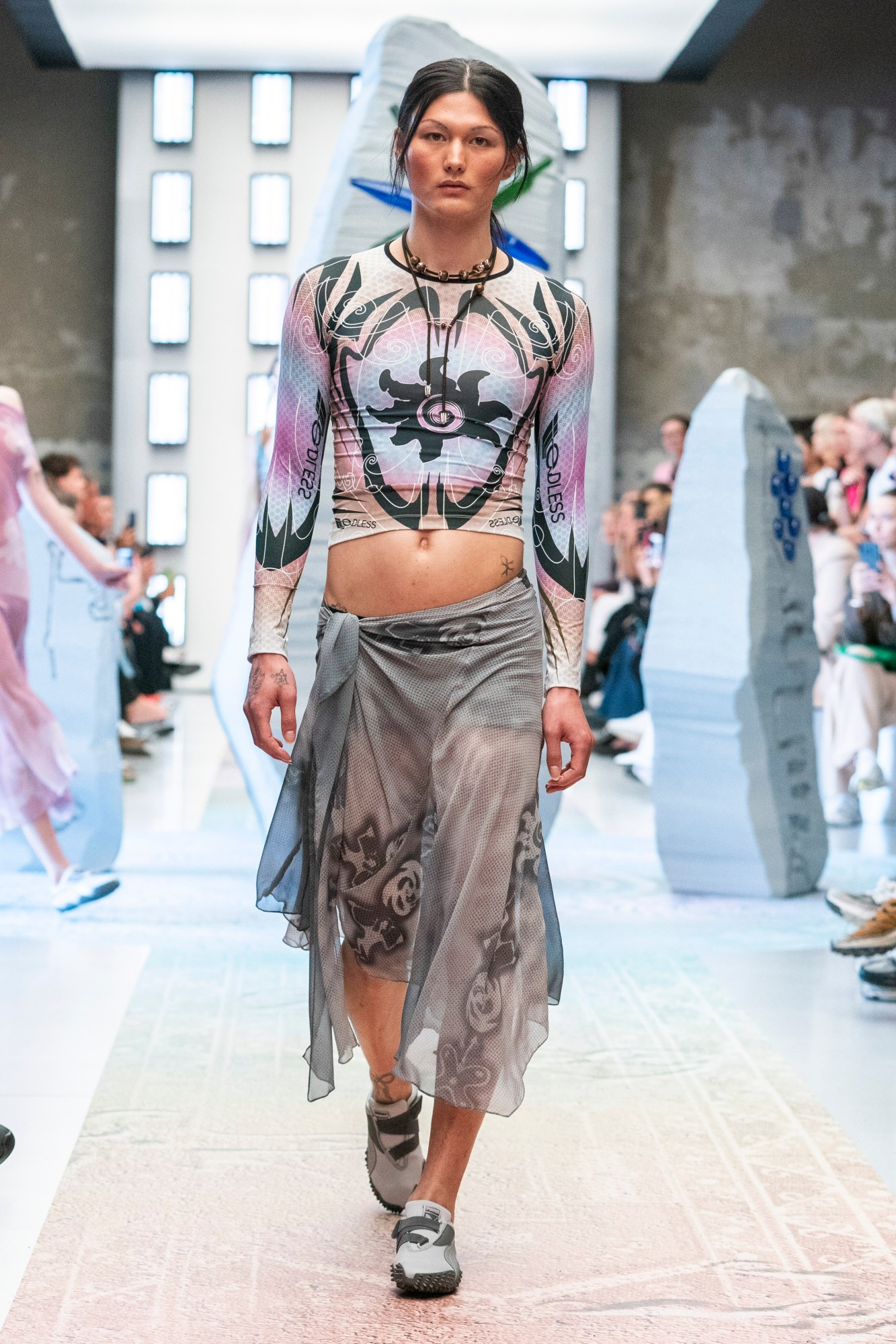 a model wearing a rash vest style patterned top with a floaty skirt on a runway