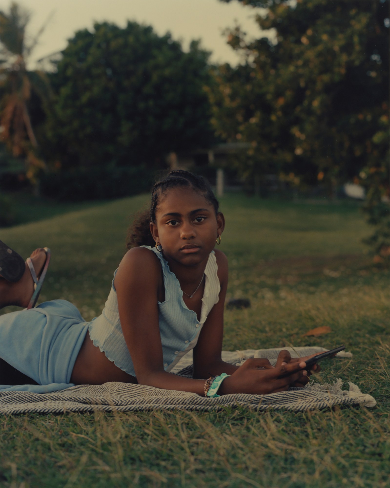 young girl on a blanket in a grassy field