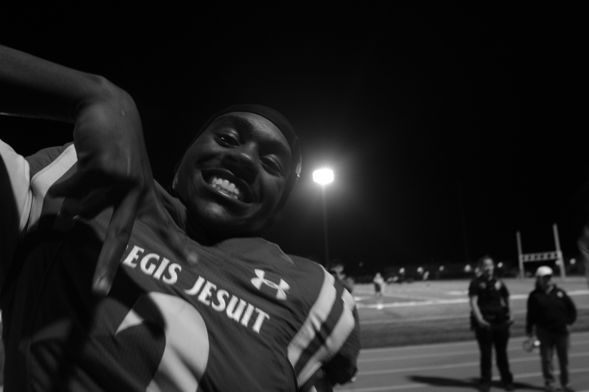 a black-and-white image of a football player smiling for the camera during a game