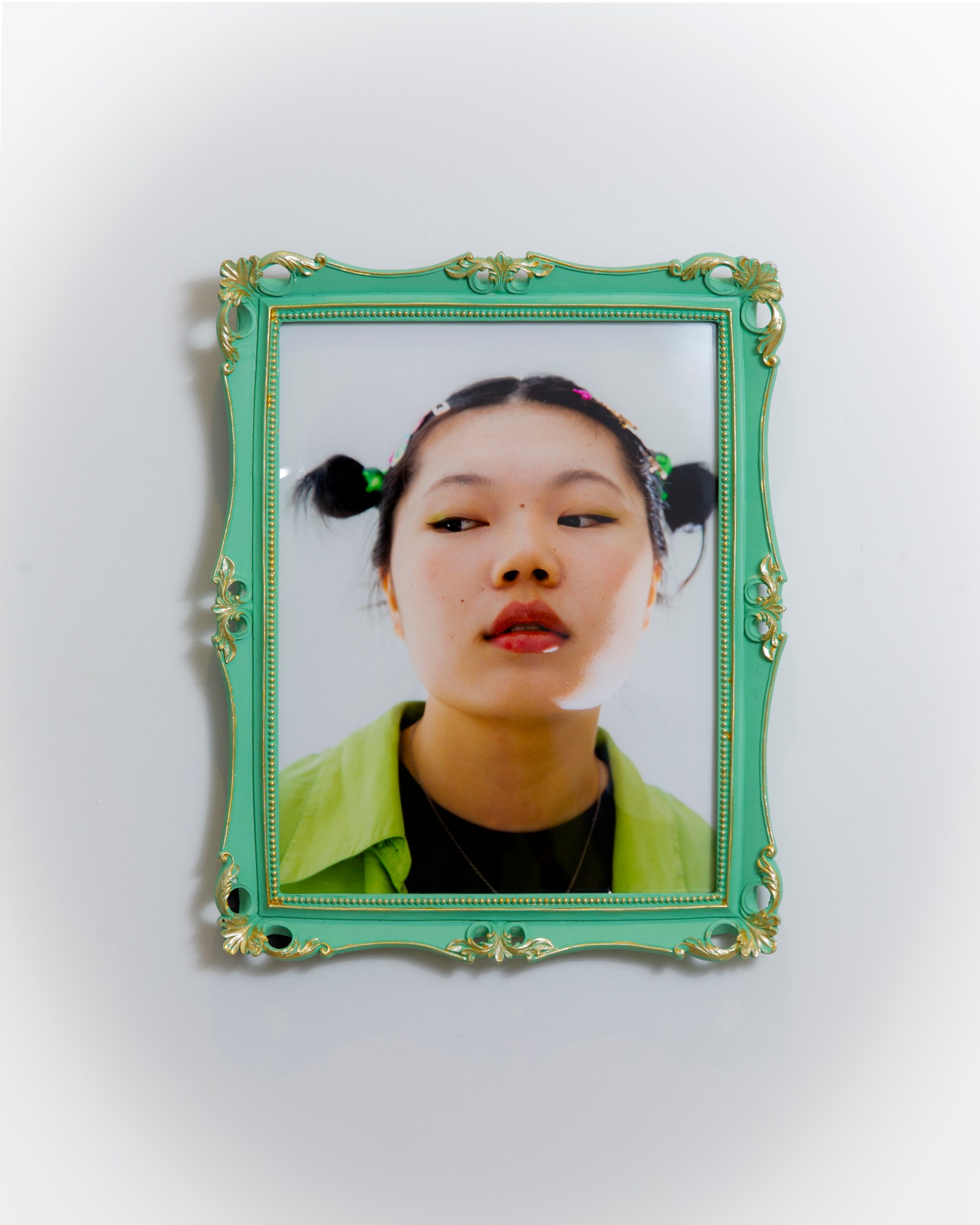 a woman with two space buns in a lime green shirt in a green frame