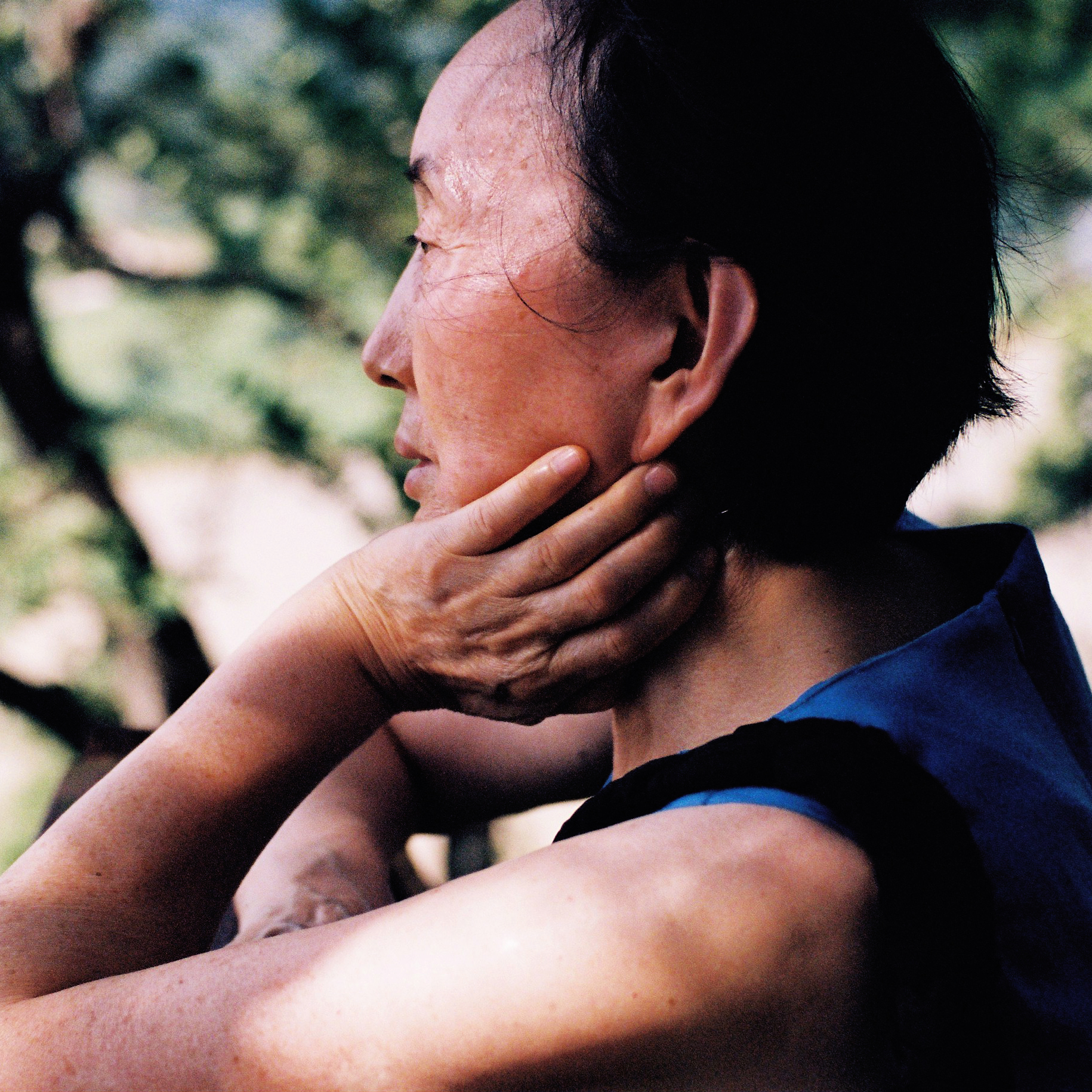 a woman holding her face in her hand shot from behind in side profile