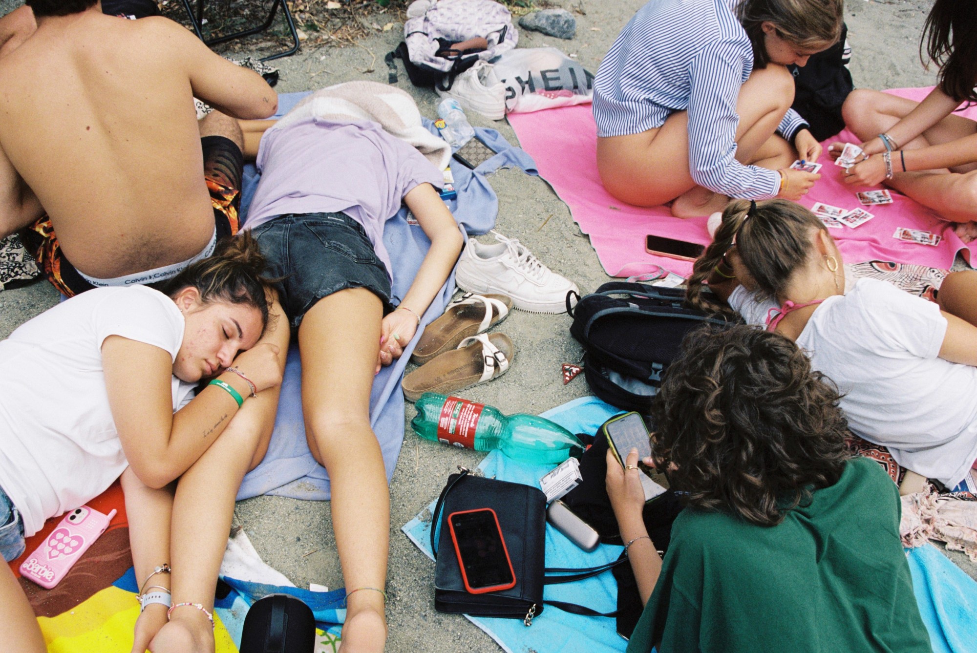 teenagers sleeping on a beach in spain