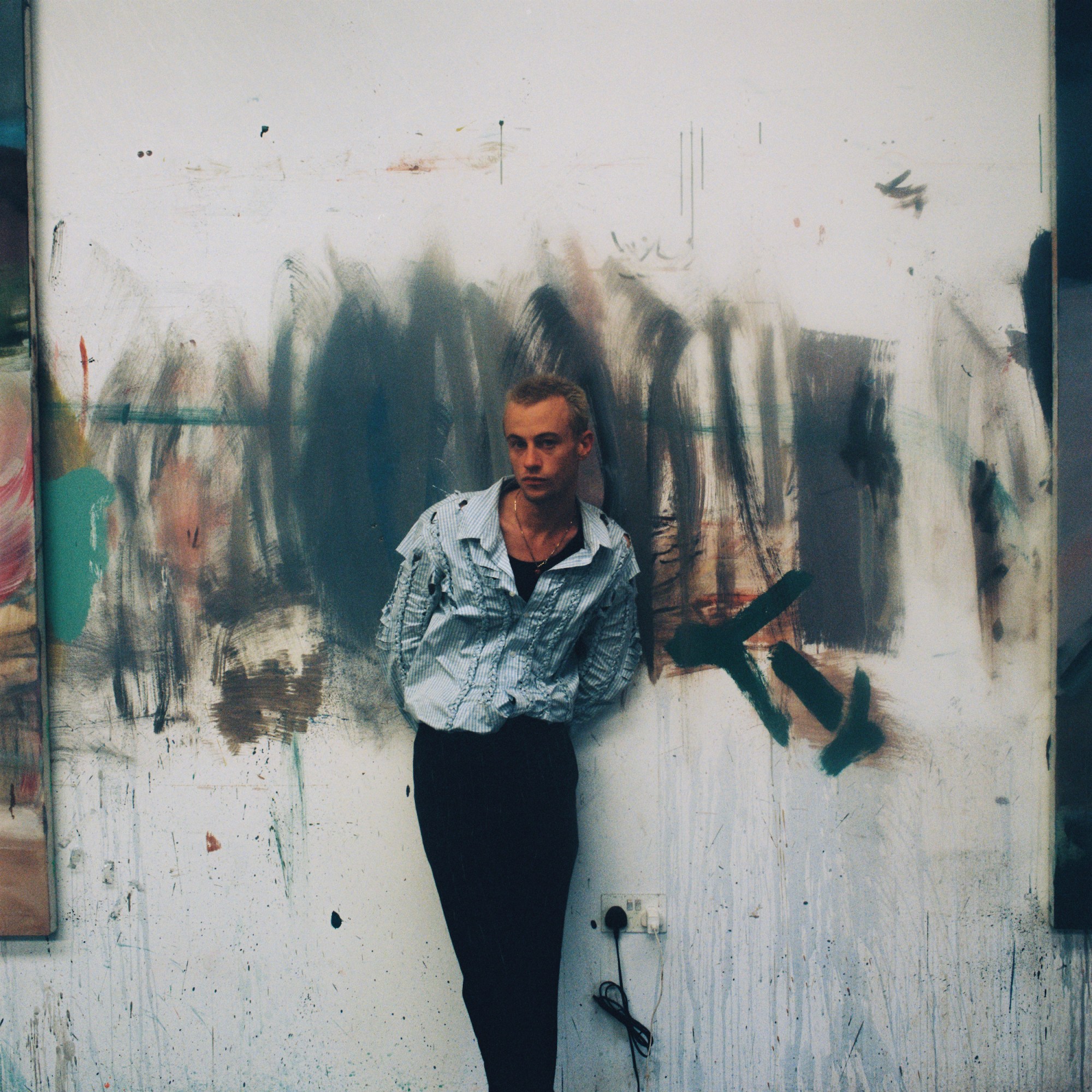 Portrait of the artist George Rouy in front of one of his paintings