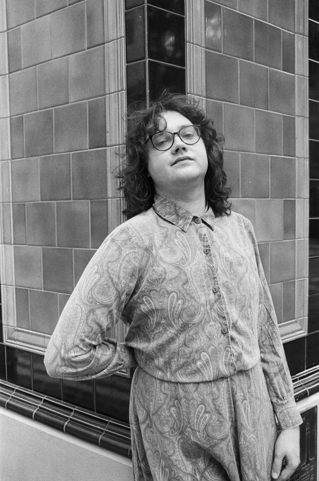 the author alison rumfitt leads against the tiled wall of a pub