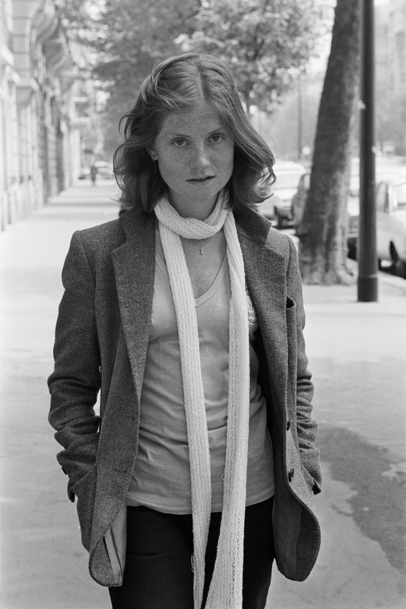 Isabelle Huppert wearing an androgynous outfit in a blazer, tee and skinny scarf in Paris in 1978