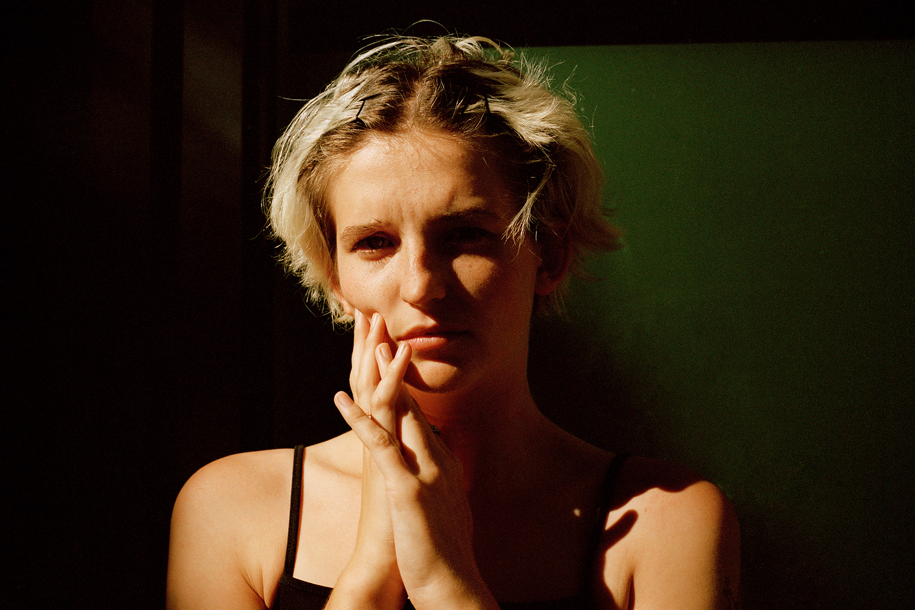 blonde person wearing black tank top posing for a portrait