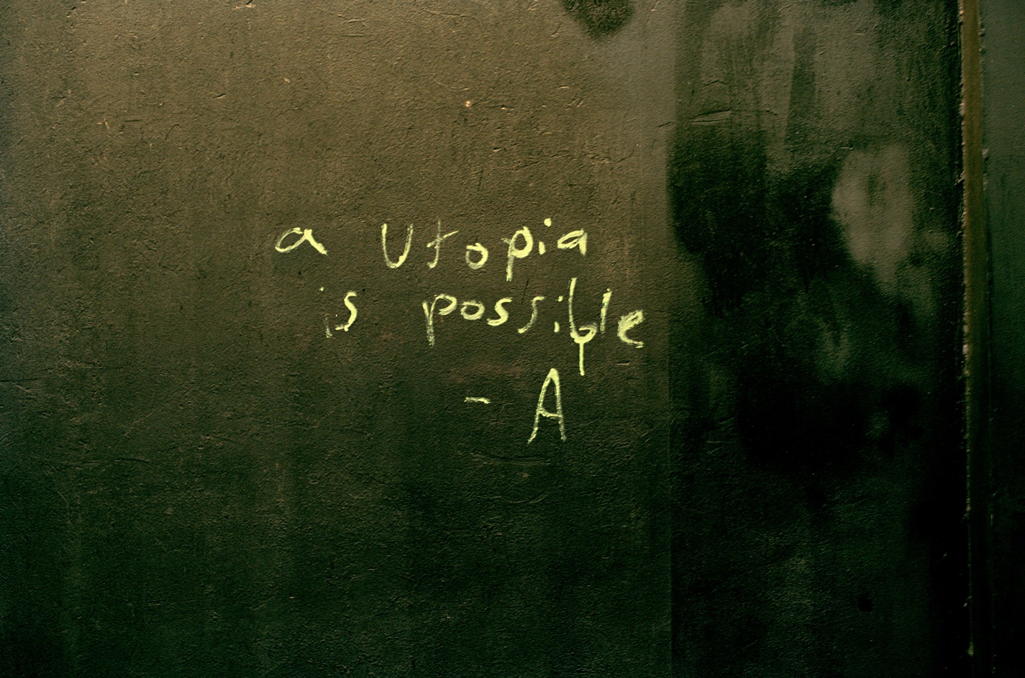 an etching on a wall that reads a utopia is possible