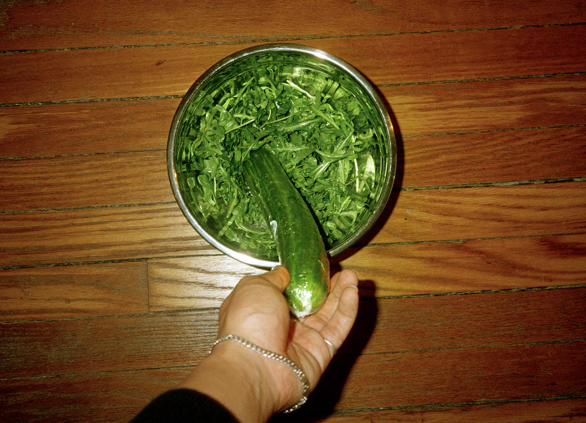 a cucumber in a bowl of arugula