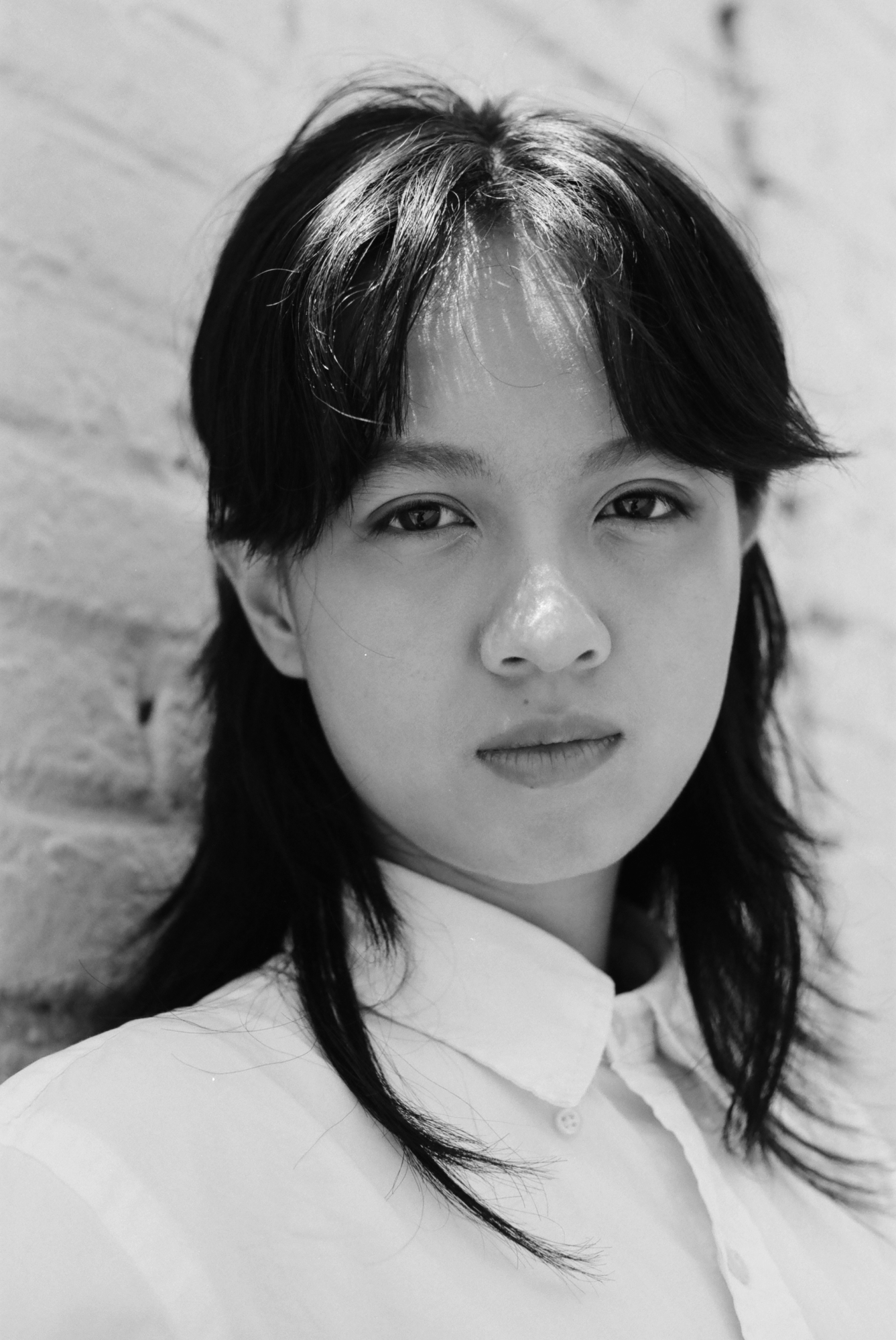 close up portrait of lucie zhang looking into the camera in a white button up