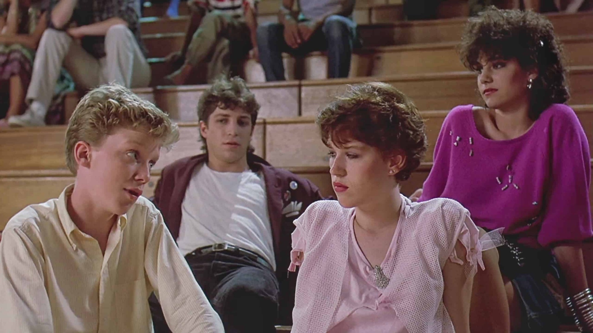 four teens, including molly ringwald, sit on the bleachers in the film Sixteen Candles (1984)