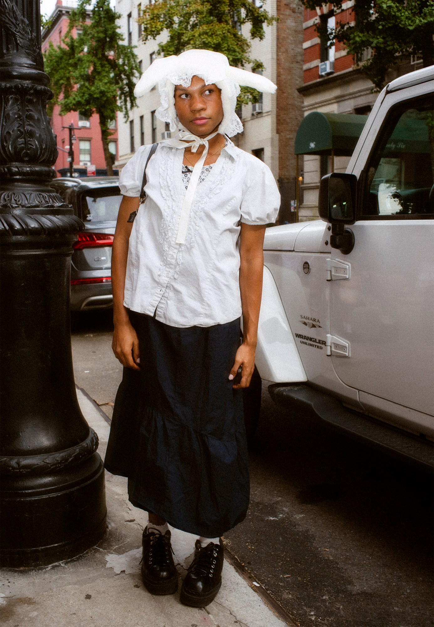 ashley markle photo of a sofia coppola fan on the streets of new york, wearing a black skirt and big black sneaers with a white shirt and bonnet