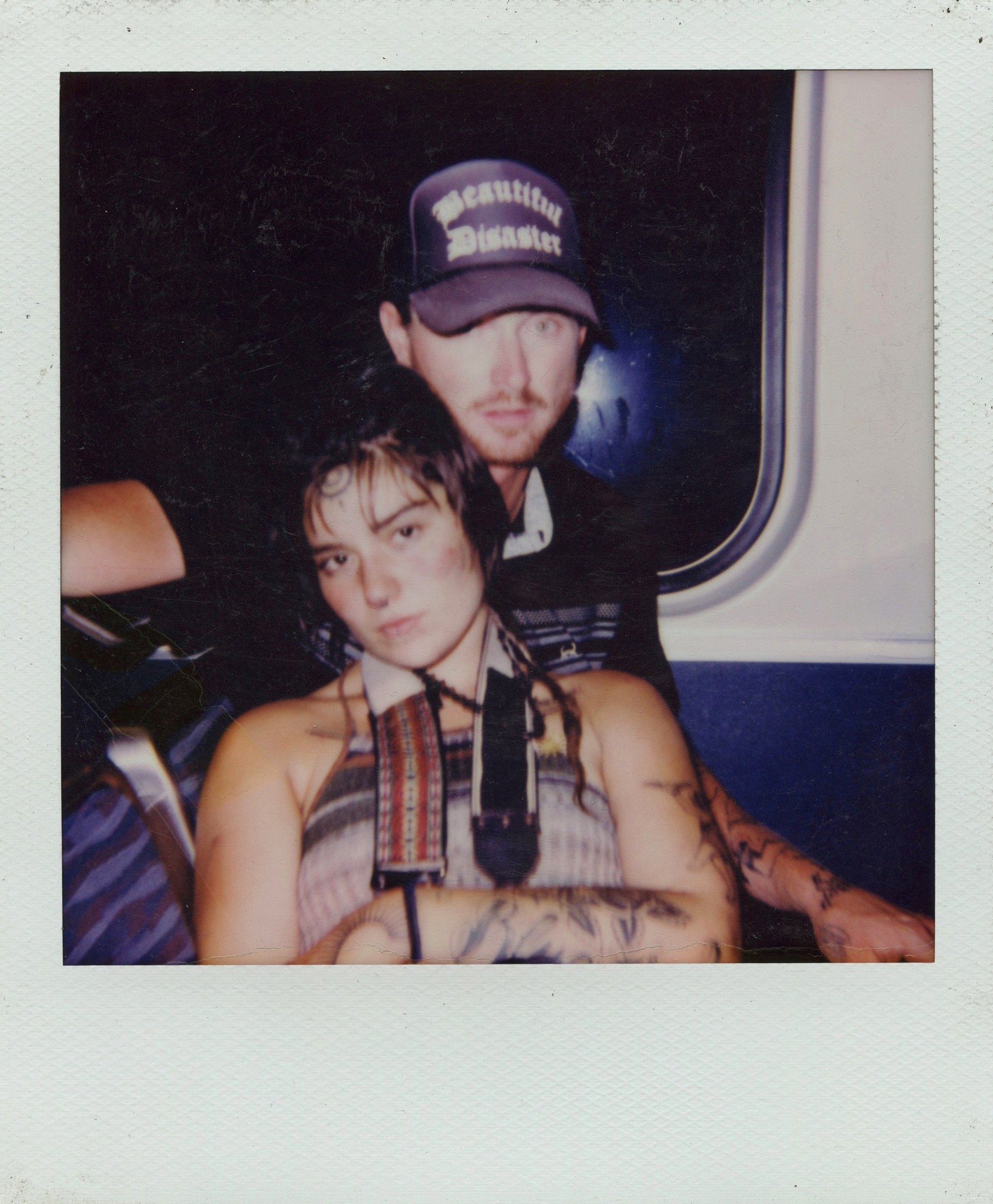 polaroid of mike and slack posing together inside of a train