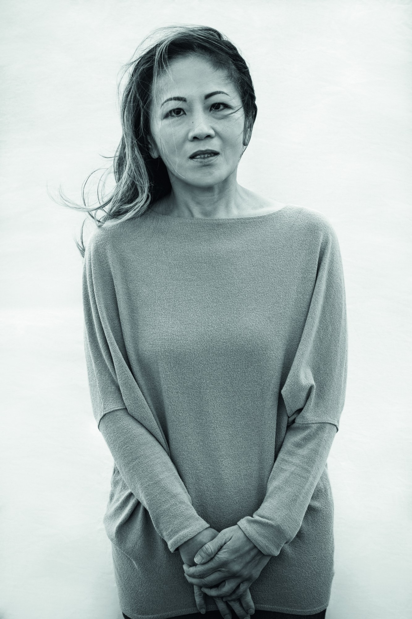 a woman in a sweater posing for a black and white portrait