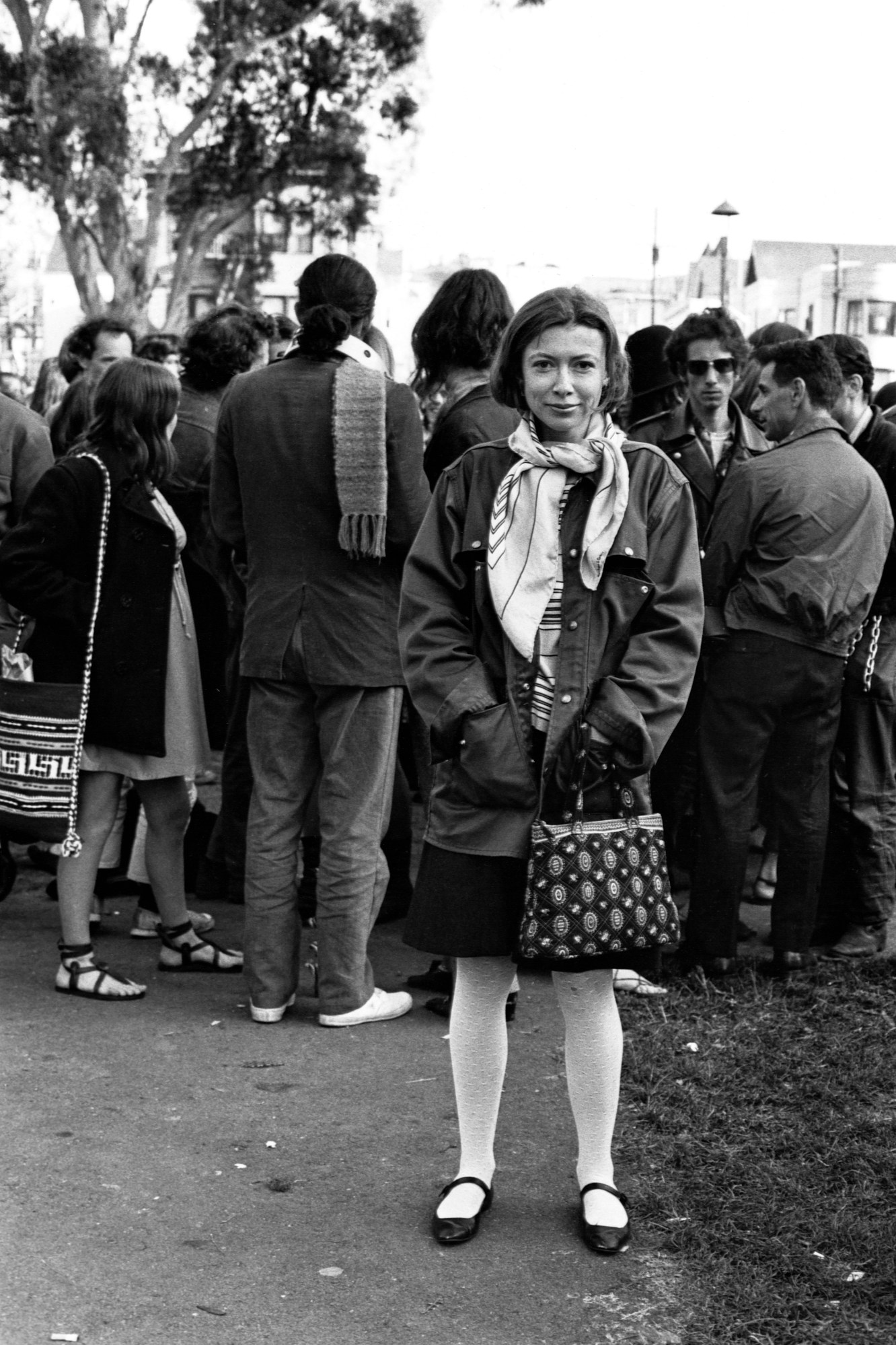 Writer Joan Didion stands at the panhandle of Golden Gate Park with a group of hippies during the writing of her article Slouching Towards Bethlehem. April 1967.