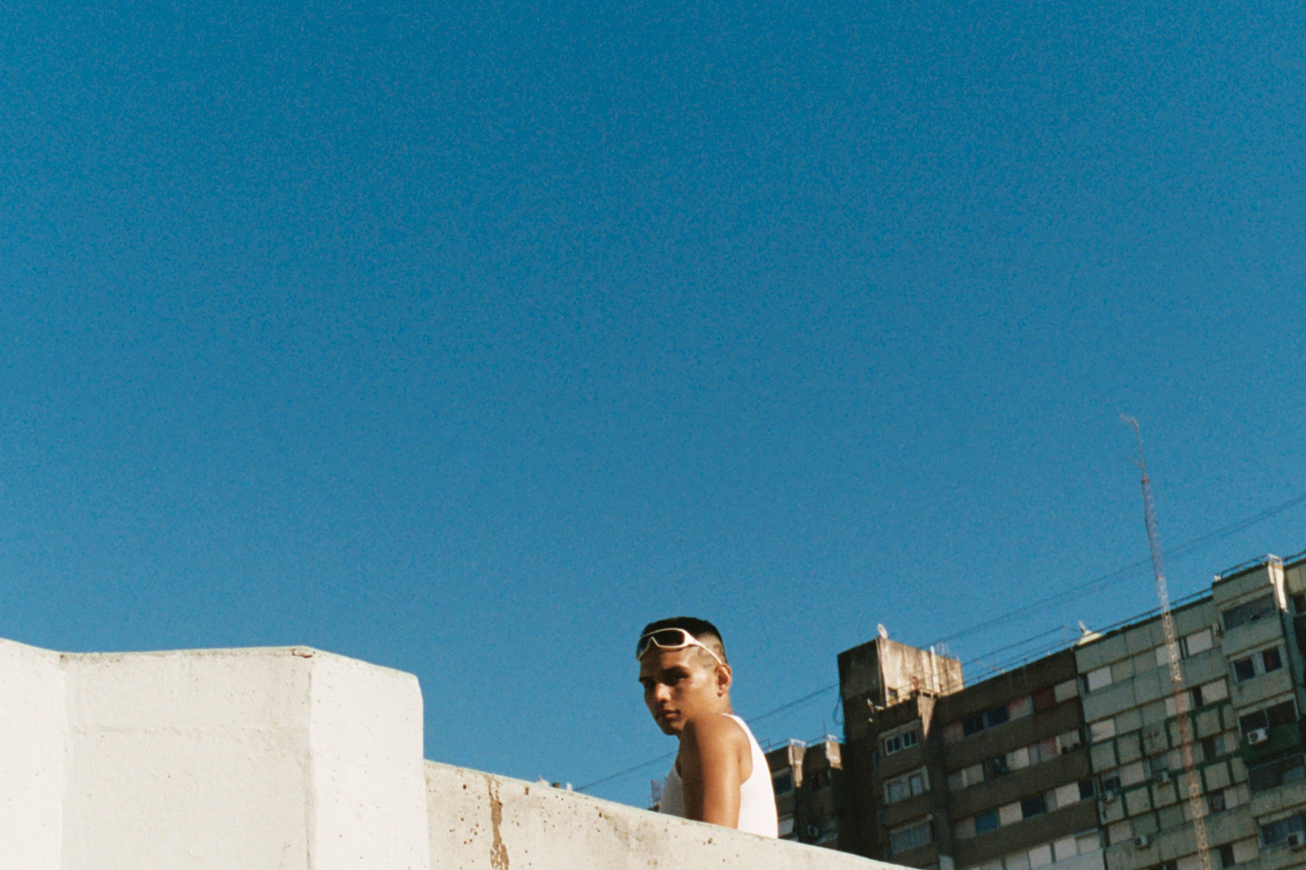 a young man looking over the top of a building