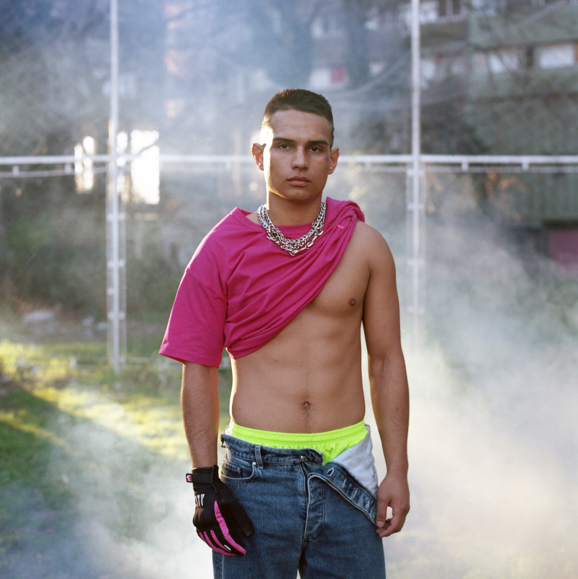 a young man in a pink shirt baring his abs