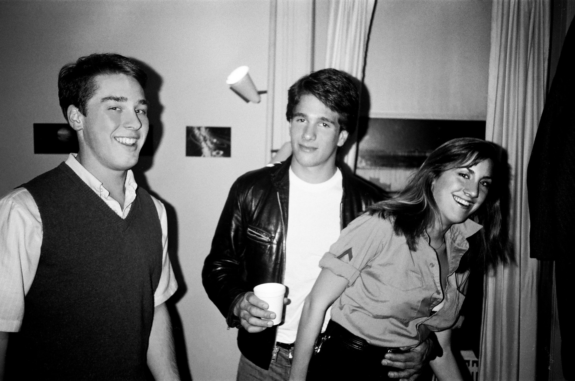 patrick mcmullan photo of todd hughes wearin a sweater vest, david burns wearing a leather jacket and nora burns in a shirt smiling.