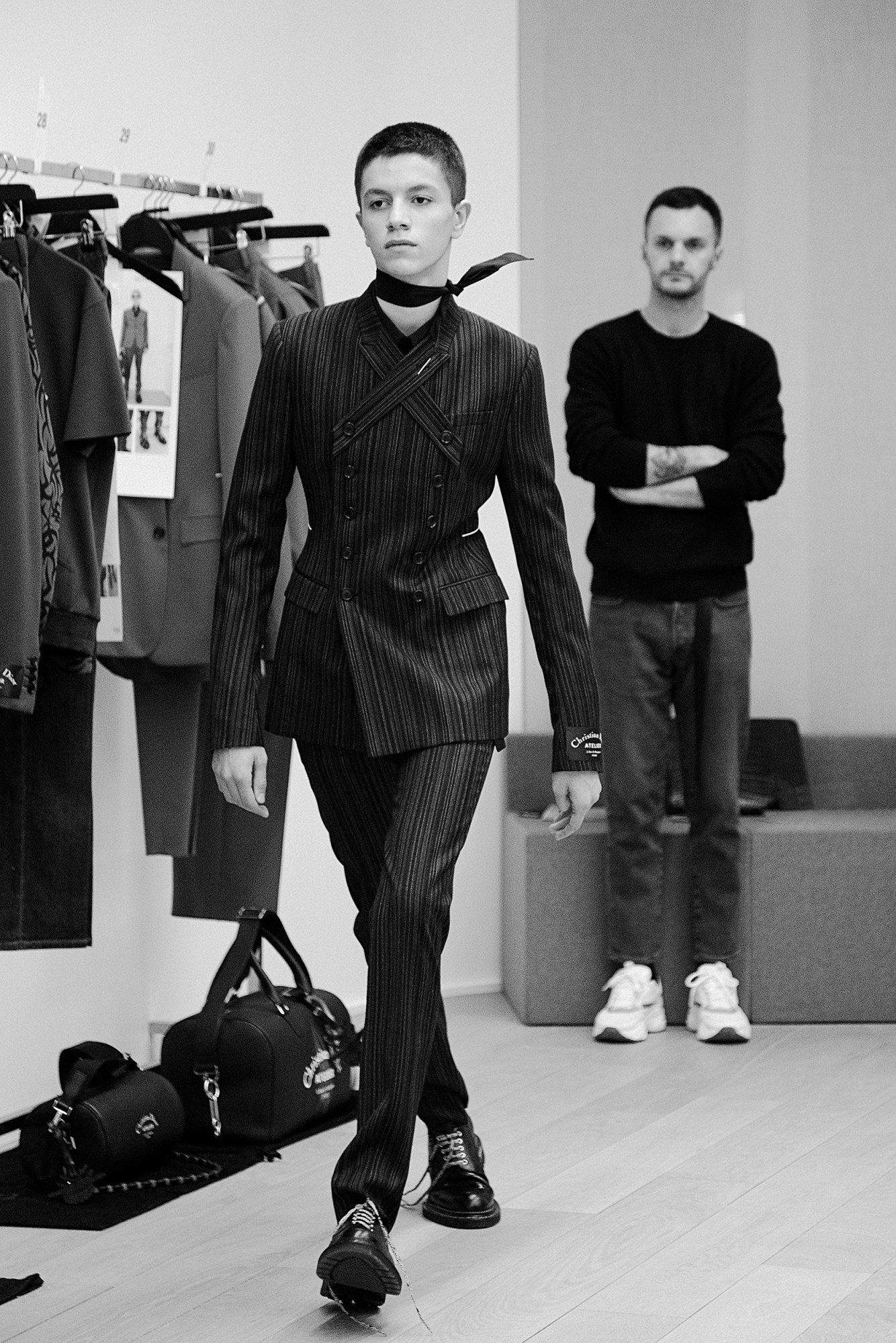 A page from 55 Collections by Kris Van Assche showing a model fitting for Dior AW18