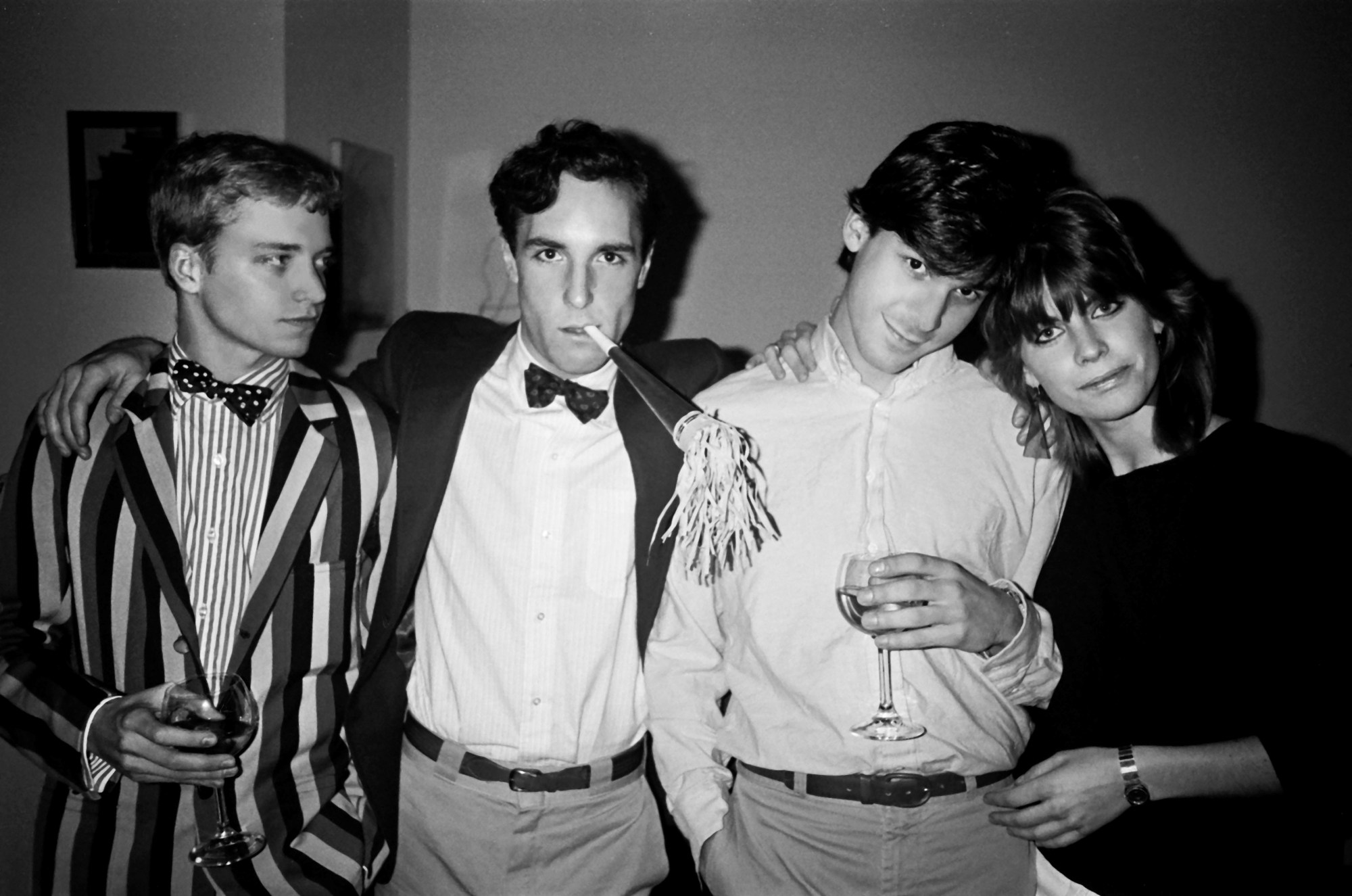 patrick mcmullan photo of a group of friends posing at a new year's eve party. a man is wearing a bow tie