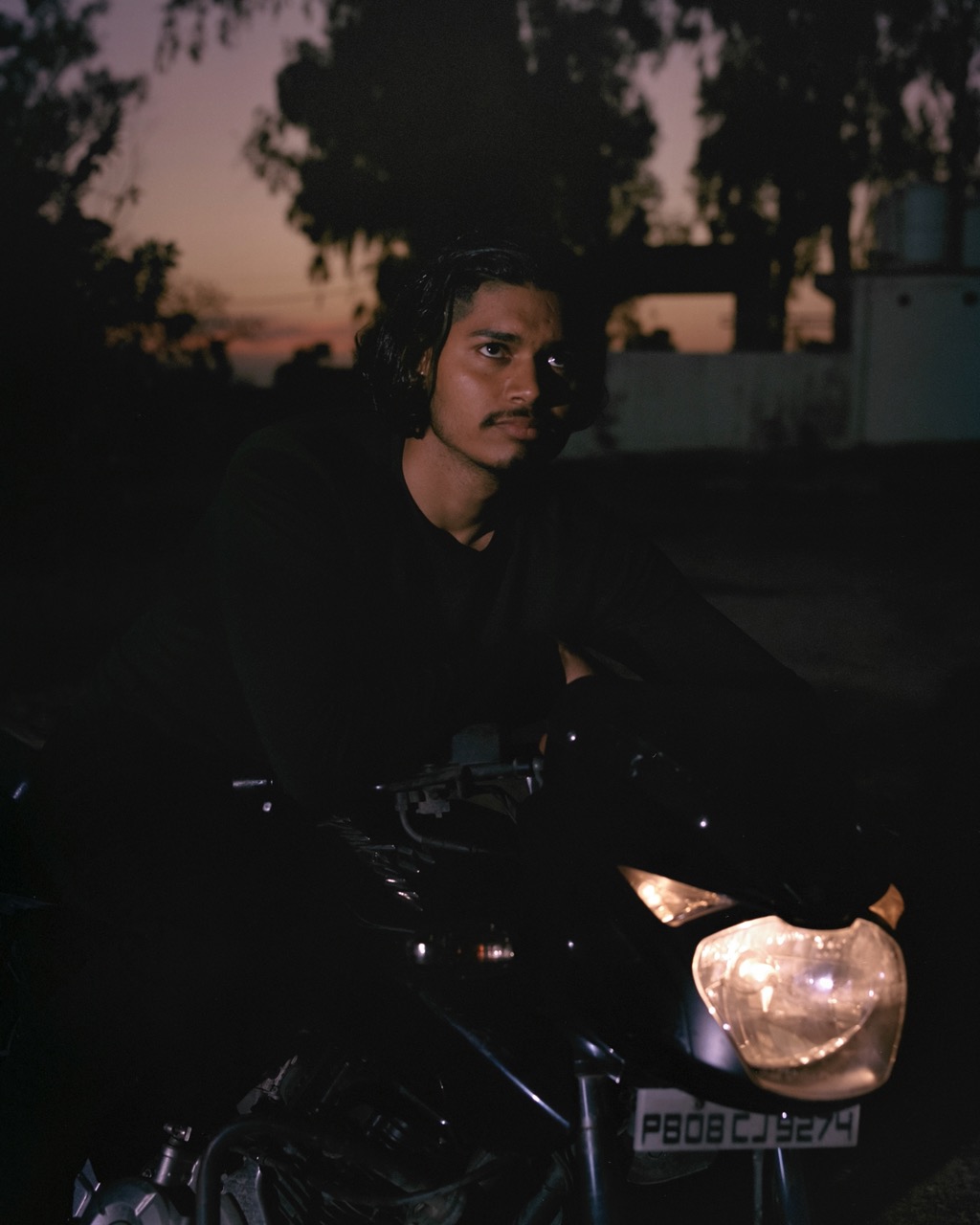 a wrestler wearing black on a motorcycle