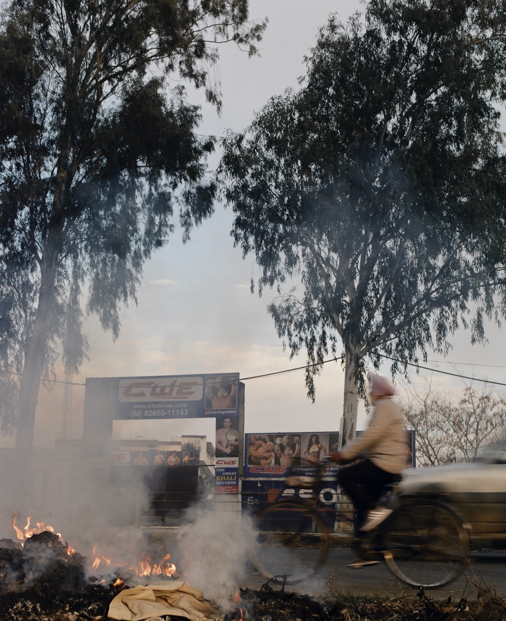 a cyclist riding past a pile of trash