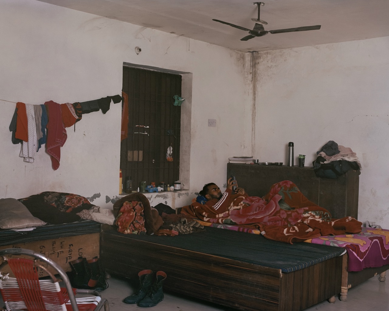 a wrestler lying on a bed with red floral blanket