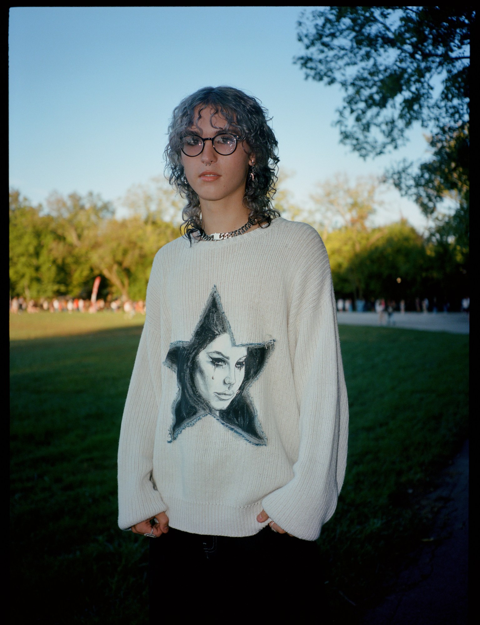 a lana del rey fan wears a sweatshirt that's white with lana del rey's face in a star on it.