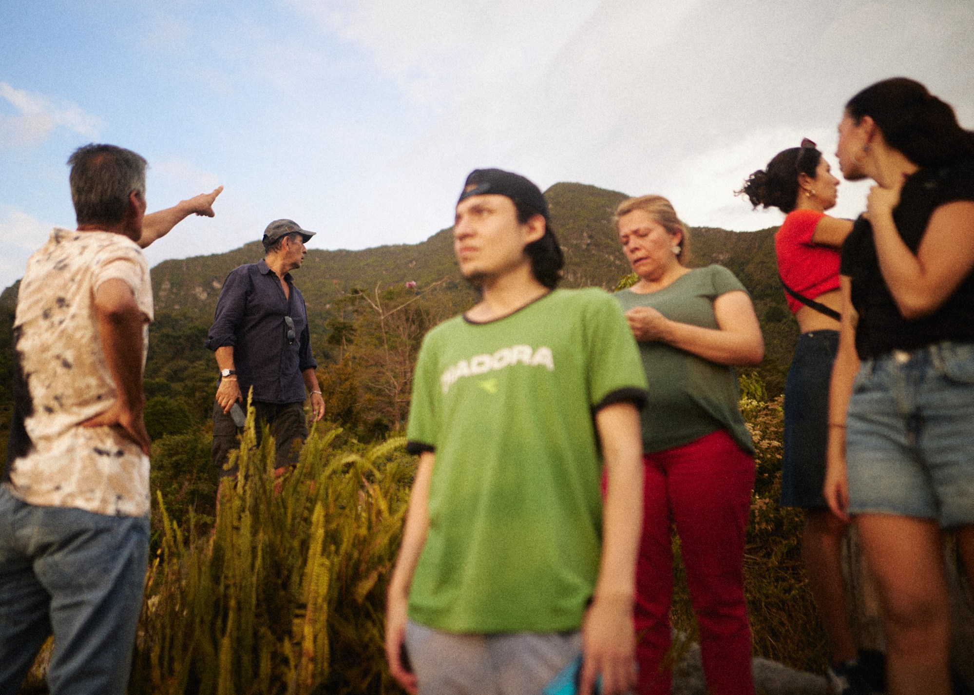 six people standing at the base of a mountain