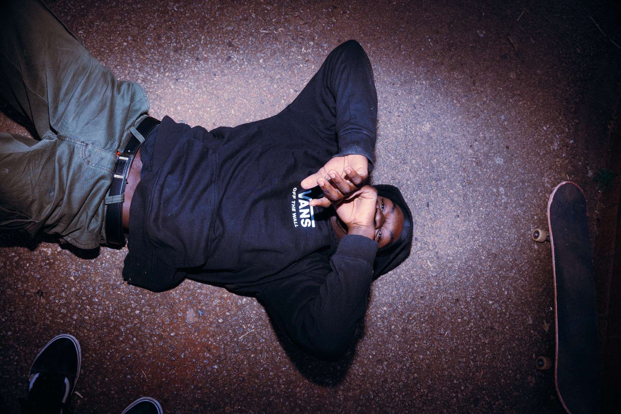 a skater in a black sweatshirt lying on the ground