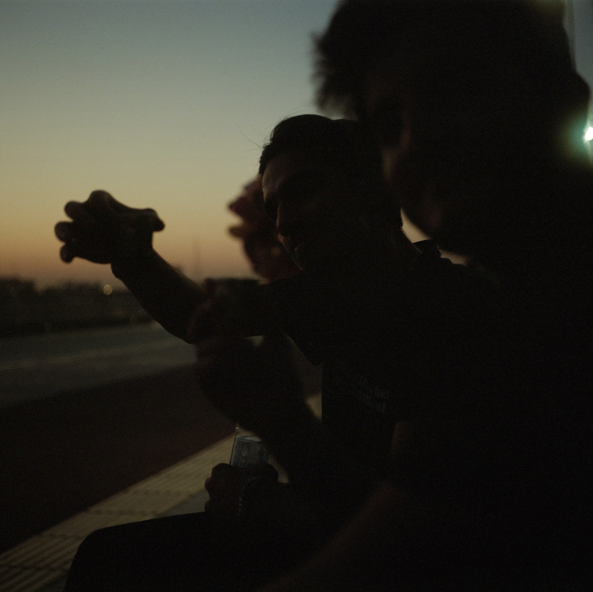 three young men hanging out at dusk