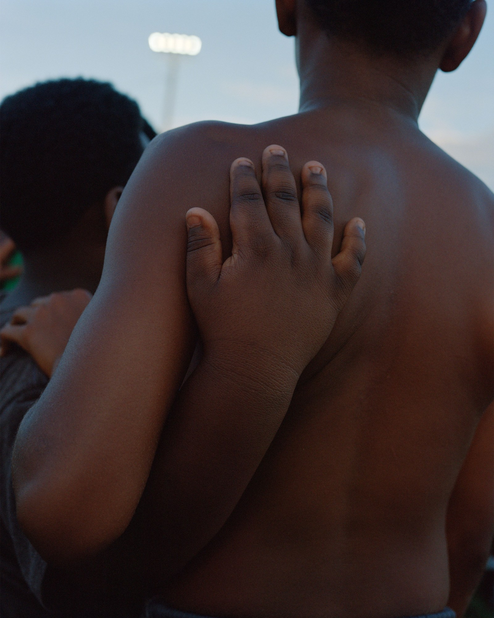 Photograph by Vasantha Yogananthan from Mystery Streets of two kids with their arms around each other