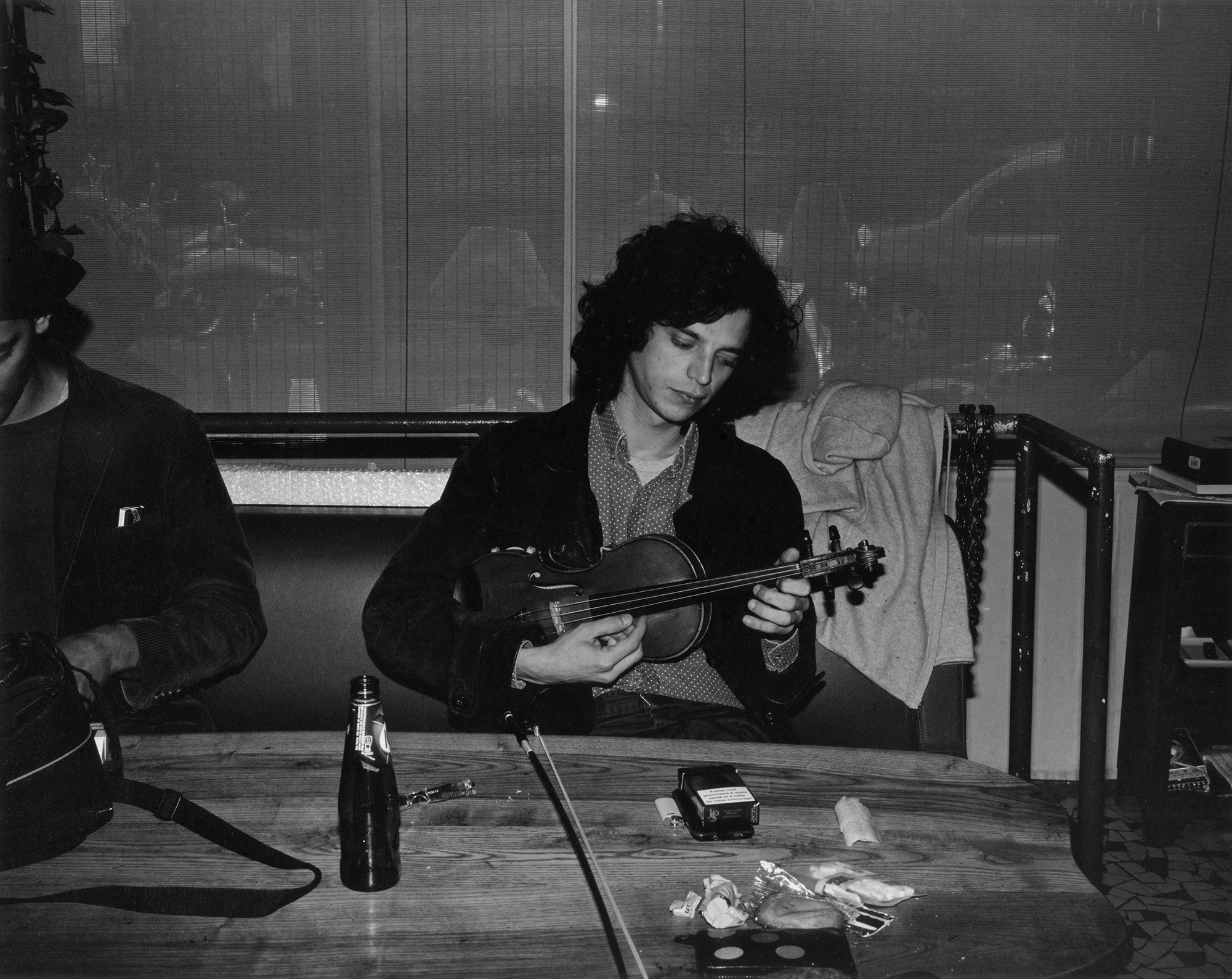 a young man in a black jacket playing a violin