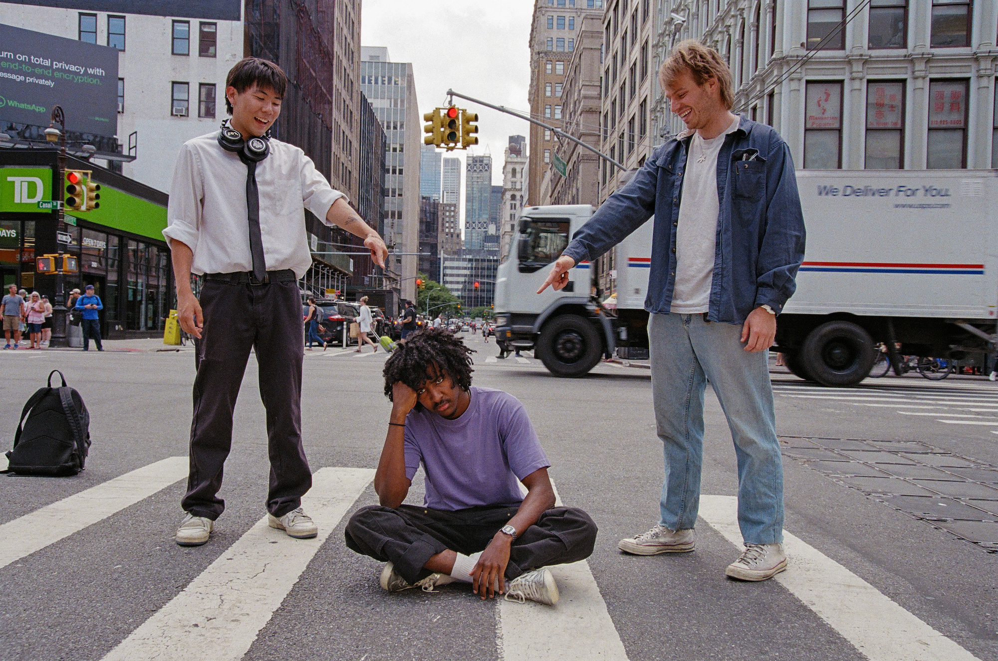 alex and chet of enzo the magazine pointing at leeban sititng in a new york city crosswalk