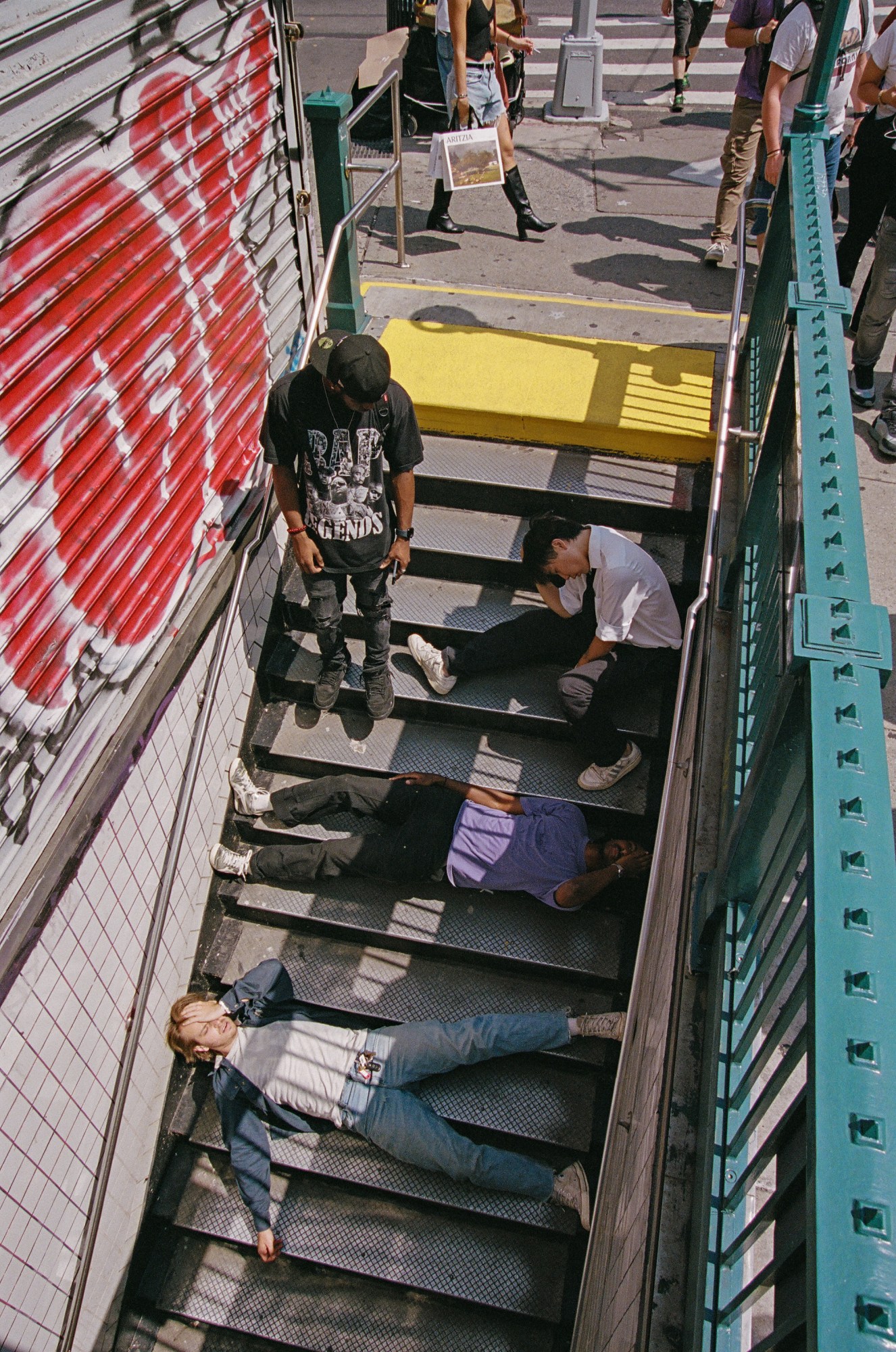 alex, chet and leeban of enzo the magazine lying in the subway stairs in new york by jacob consenstein