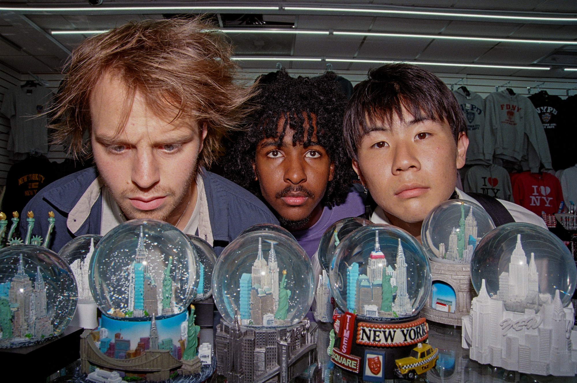 founders of enzo the magazine standing in a tourist shop looking at new york snowglobes