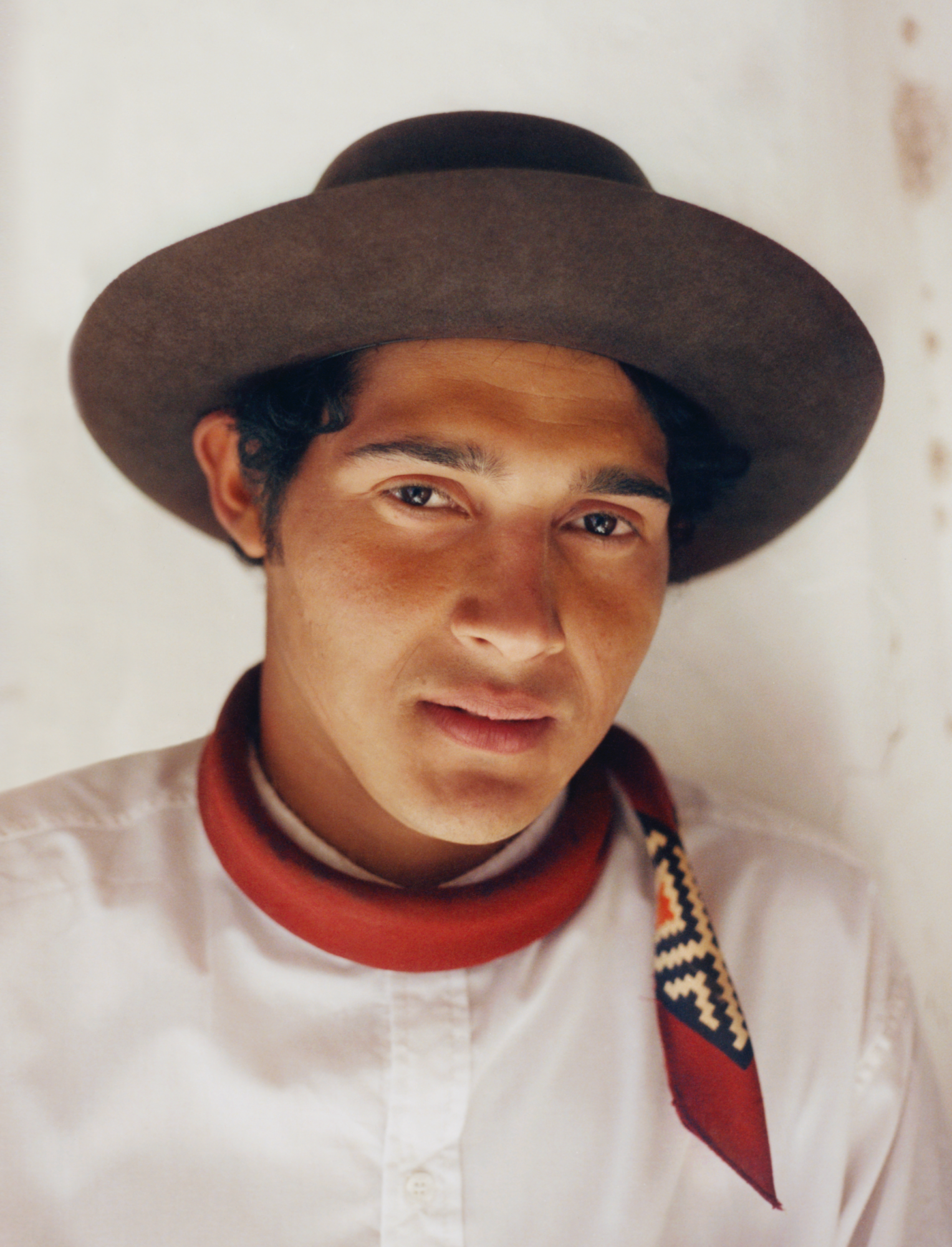 a gaucho wearing a black hat and red scarf