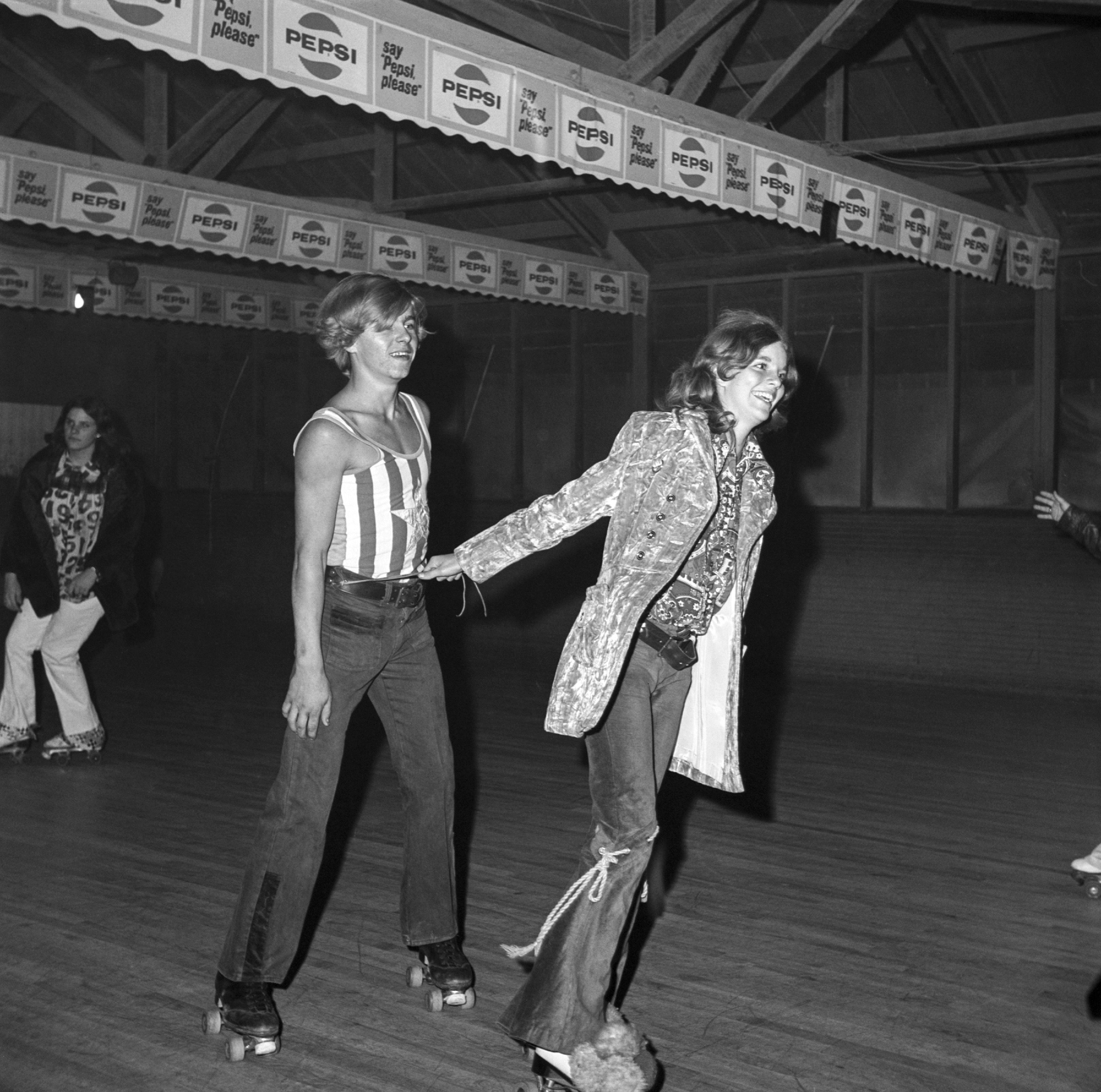 black-and-white image of two teenagers roller skating in florida