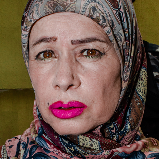 A woman in a headscarf and vibrant pink lipstick