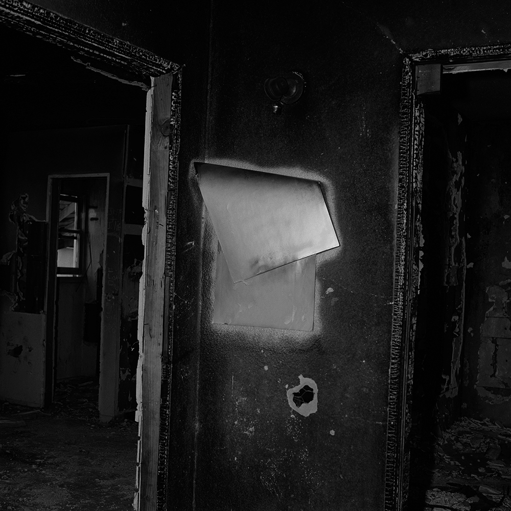 a black and white shot of a dark, dilapidated room