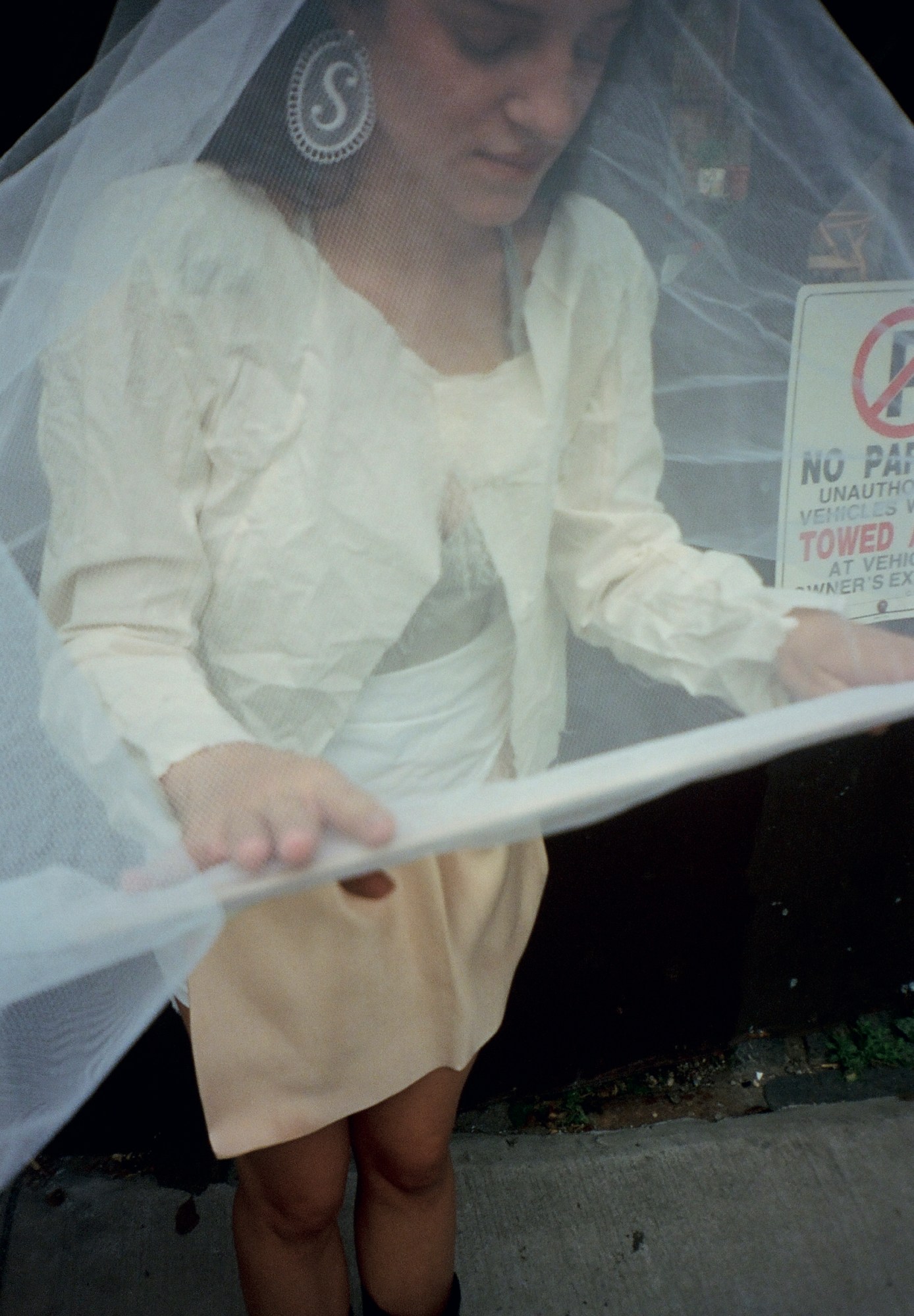 sydney arnold wearing a fabric veil and S earrings photographing outside by shayna arnold