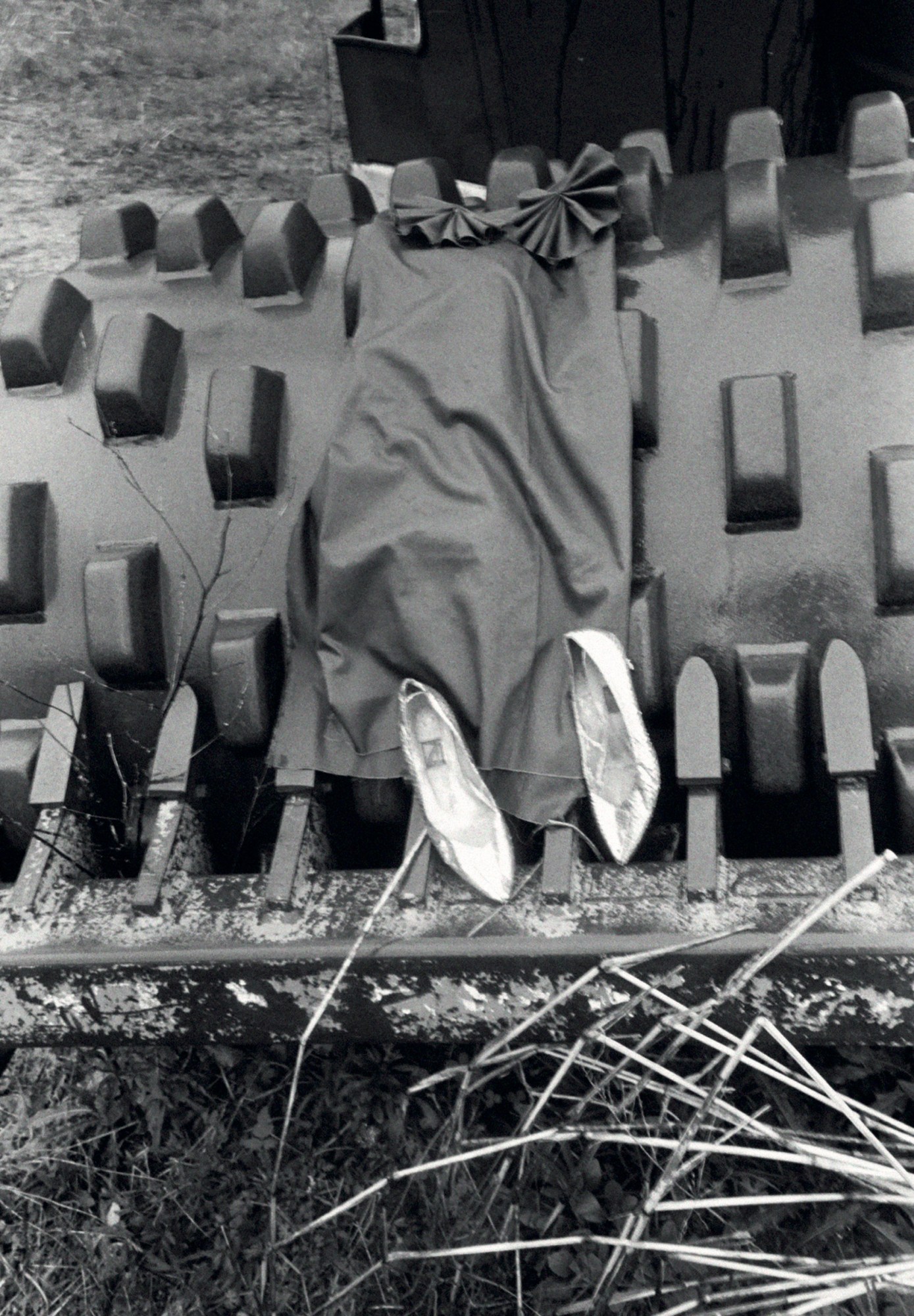 a dress and shoes lying on top of a bulldozer and grass