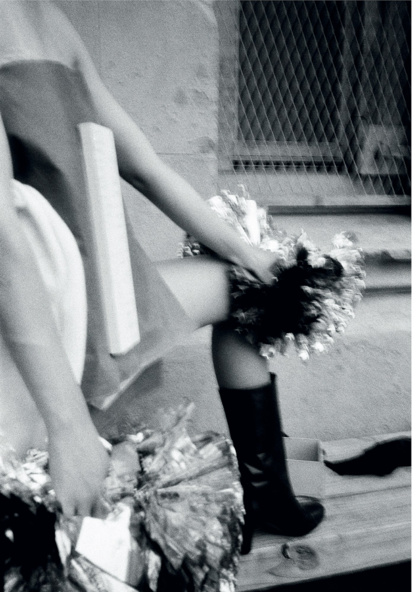 legs, boots and pom poms photographed on a wooden bench