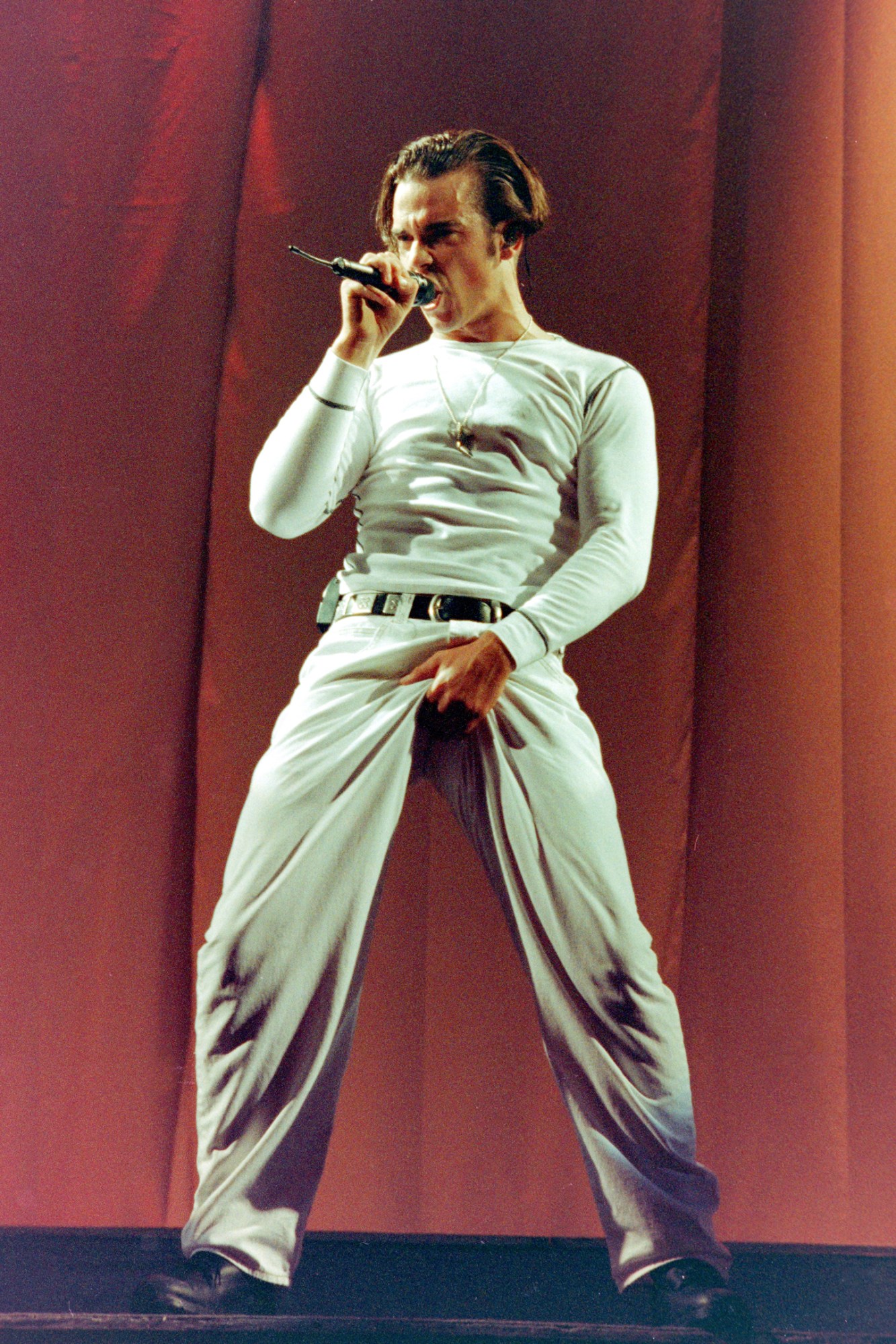 robbie williams on stage in 1993 wearing an all-white outfit