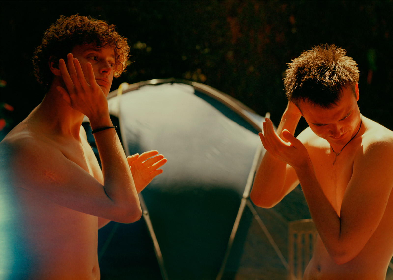 two people shirtless with their hands on their faces