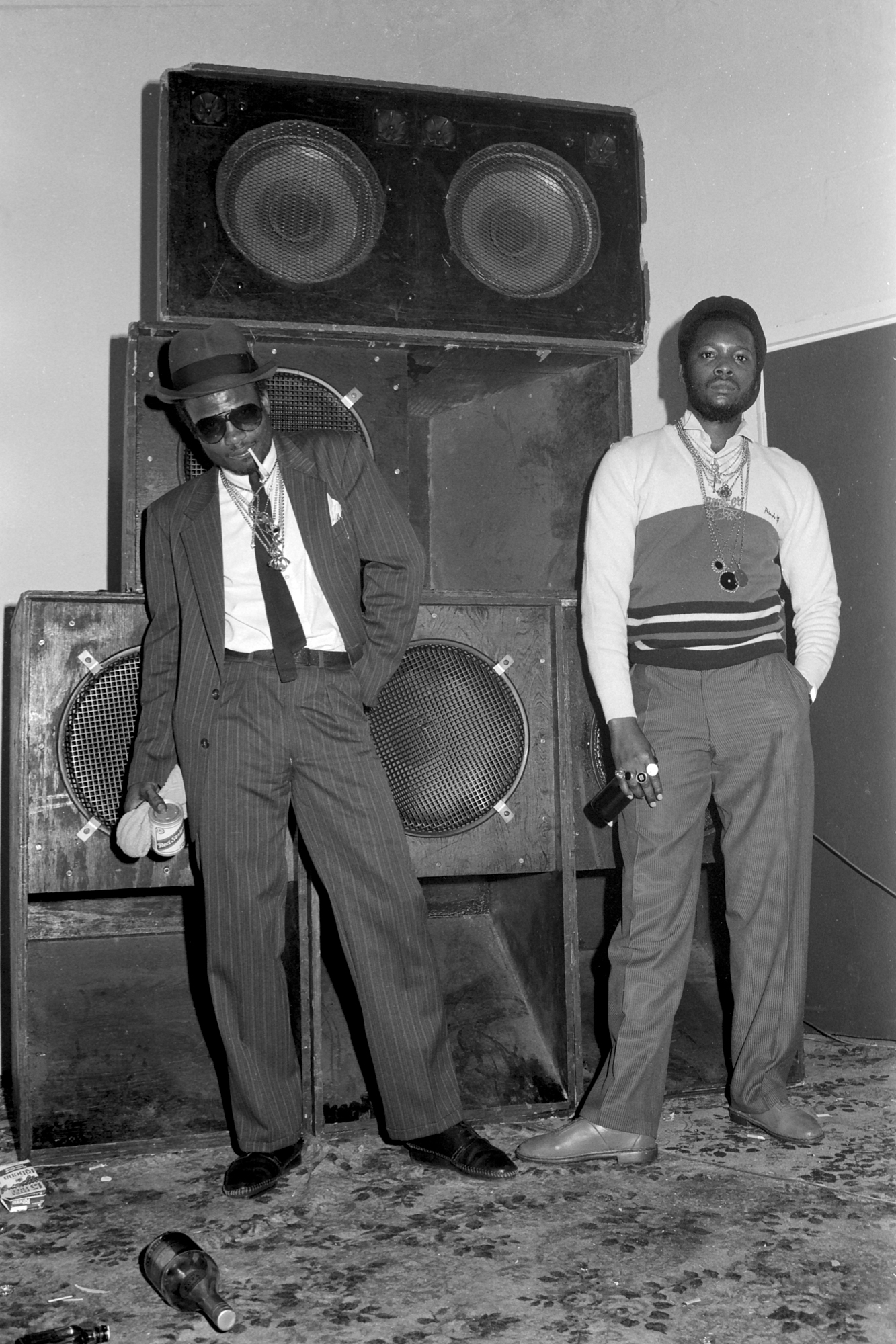 two well dressed men wearing stacks of necklaces