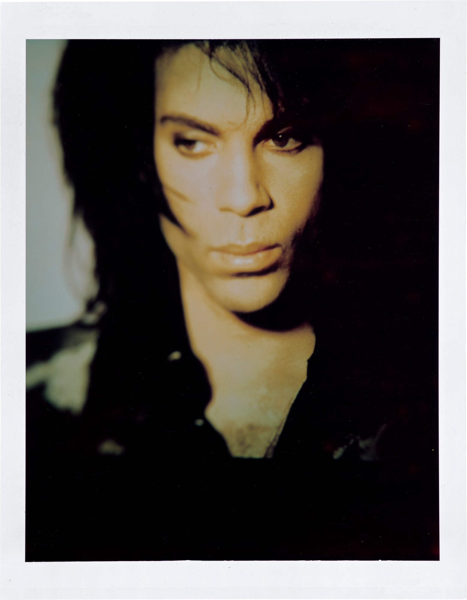 A polaroid of Prince wearing a black shirt