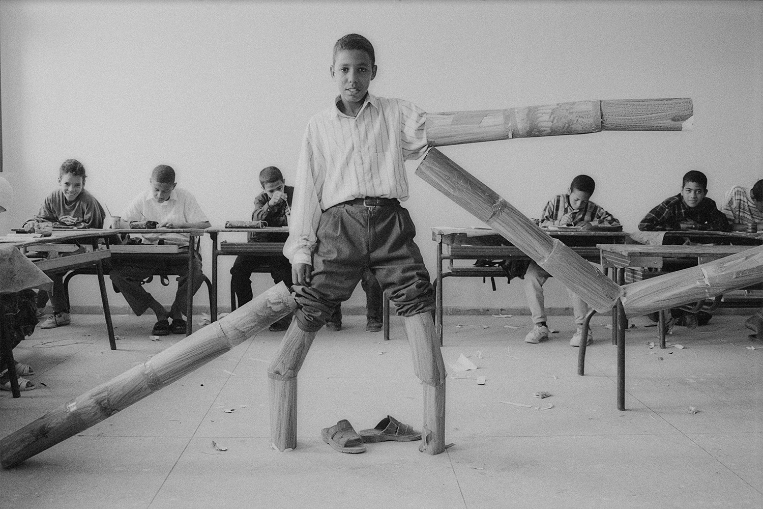 black-and-white photo of students in a classroom plying with fake arms and legs