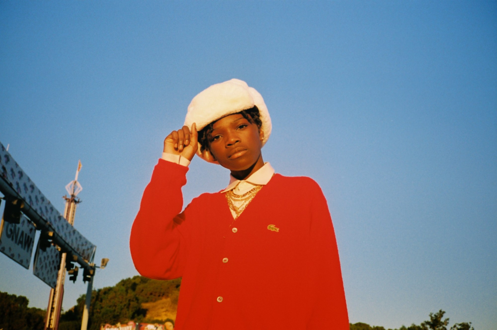 camden coley dressed like tyler the creator against a blue sky in los angeles