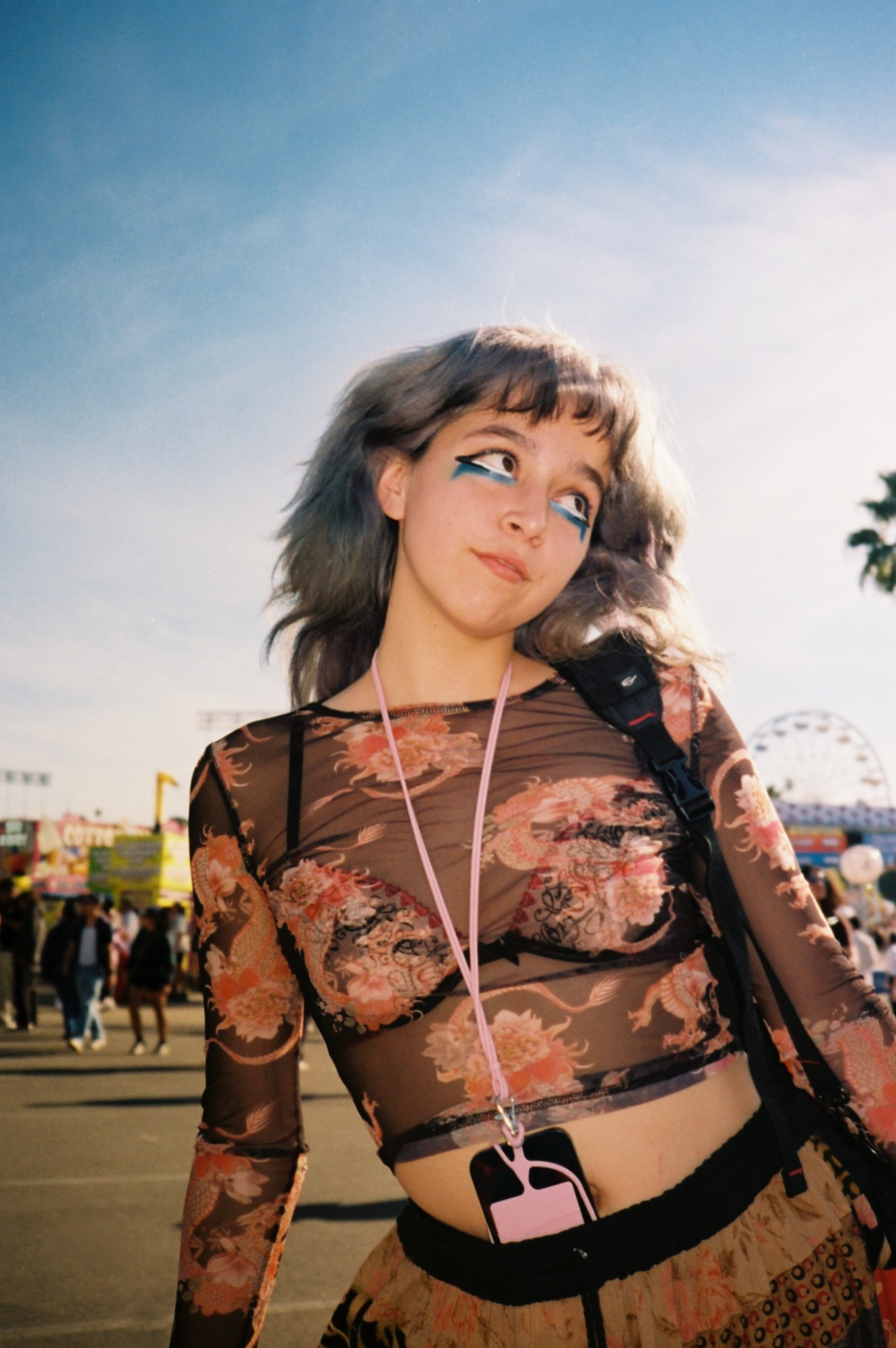 a girl in blue eye makeup wearing a mesh dragon top